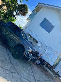 Custom Marble Installation at a Modern Home: A truck from Absolute Marble Service parked outside a contemporary white home, delivering a stunning marble slab for installation, showcasing premium construction services.