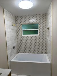 Minimalist Bathroom with Dual Vanity and Chevron Pattern Wall: A sleek bathroom design with a dual vanity, chevron-patterned wall tiles, and brass fixtures for an upscale, minimalist feel.