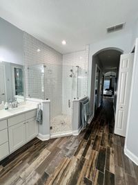 Classic Bathroom with Subway Tile Shower and Rustic Flooring: A bathroom combining a subway tile walk-in shower and rustic wood-look flooring for a cozy, timeless appeal.