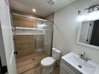 Bathroom with Dual Vanity and Geometric Wall Design: A bright bathroom showcasing a dual vanity with marble countertops, a white soaking tub, and patterned tiles for a clean, contemporary aesthetic.