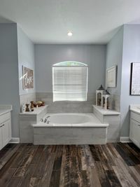 Rustic-Inspired Bathroom with Hexagon Tile Flooring: A contemporary bathroom featuring black hexagon floor tiles, green cabinetry, and a wood vanity, blending rustic charm with modern design.